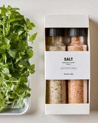 Nicolas Vahé Parmesan and basil and chilli salt gift box beside fresh basil on a metal tray