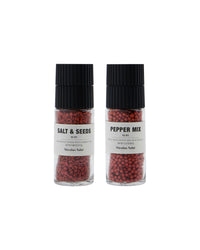 Nicolas Vahé ruby salt and seeds grinder next to a ruby pepper mix grinder