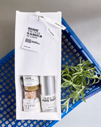 Nicolas Vahé Because Truffle Is Always in Season gift bag on a blue crate with fresh rosemary