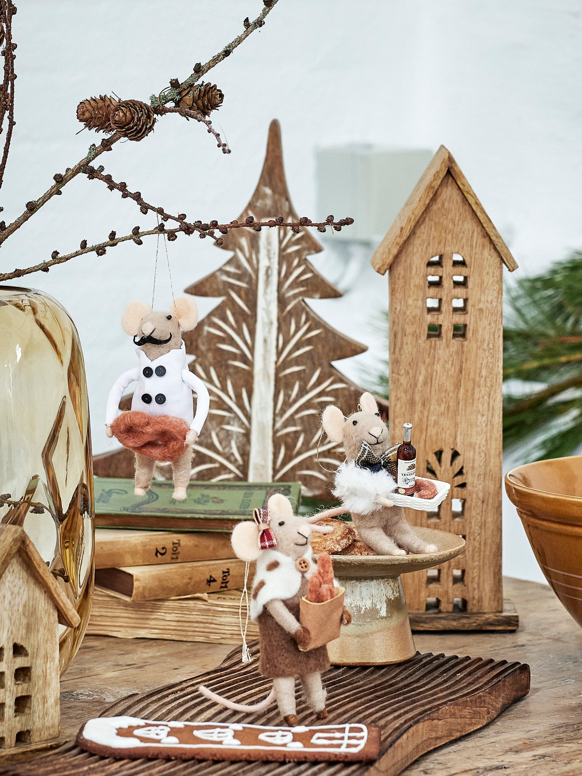 Felt wool mice Christmas decorations displayed with wooden houses and festive scene
