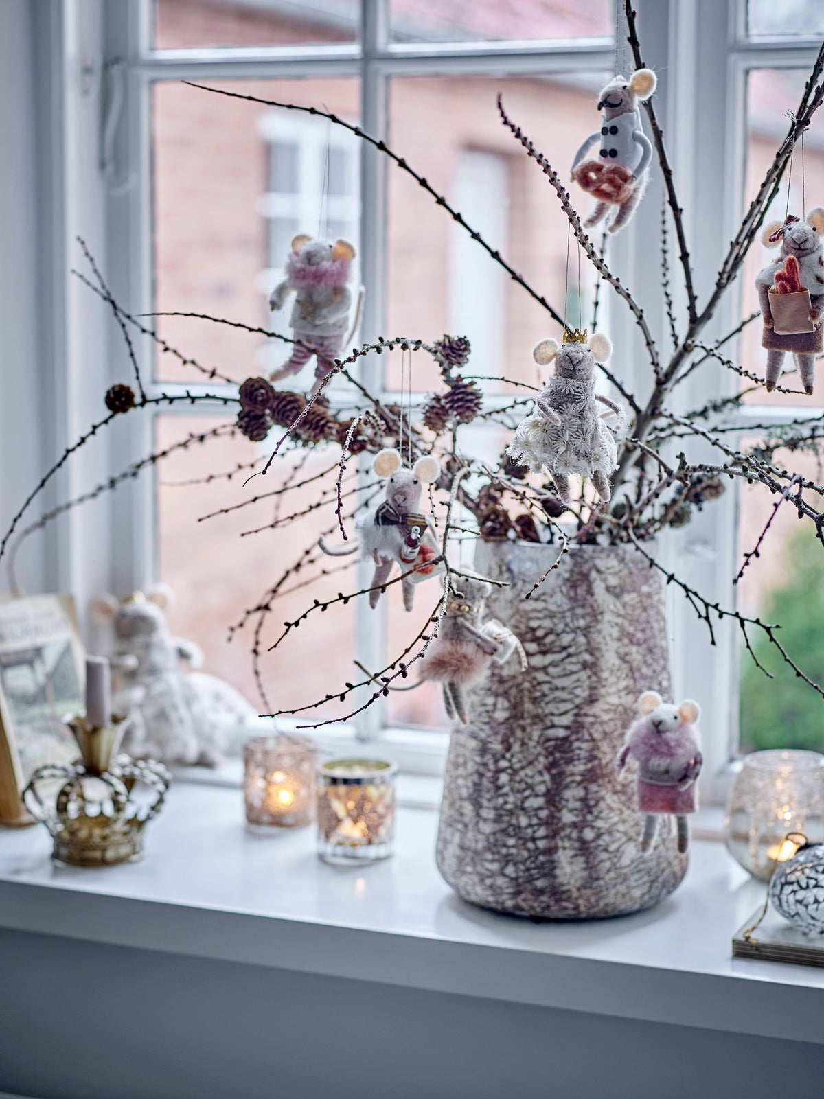 Felted wool mice Christmas ornaments hanging from winter branches in a vase