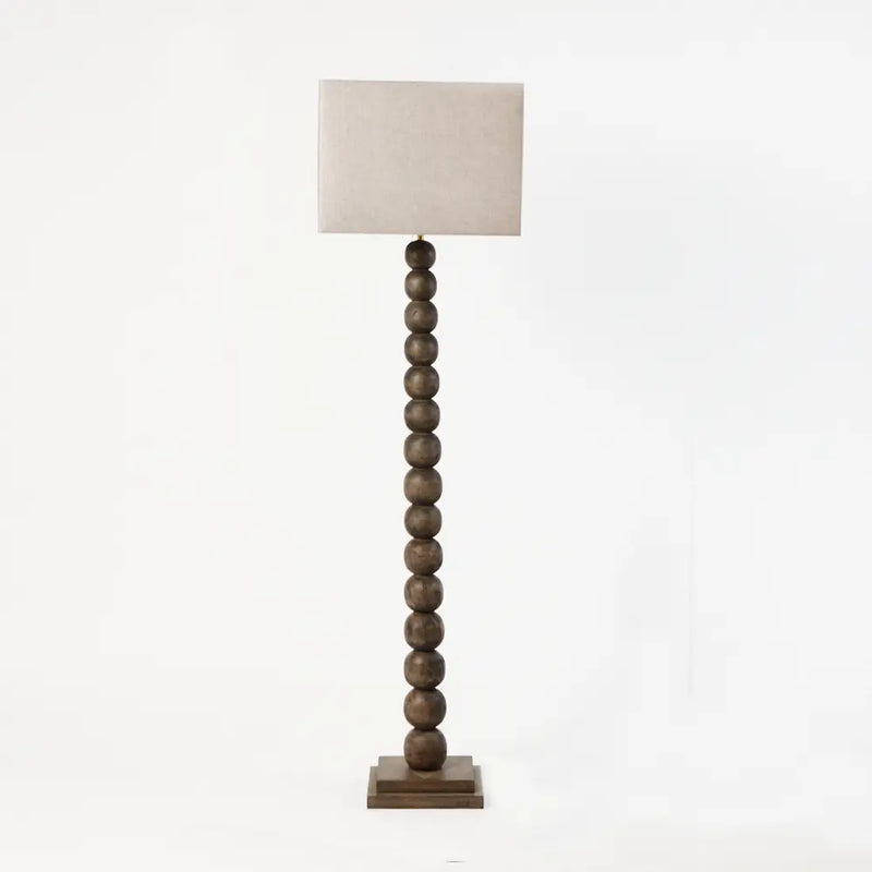 Preston turned wooden floor lamp by Olsson & Jensen, shown with a linen shade