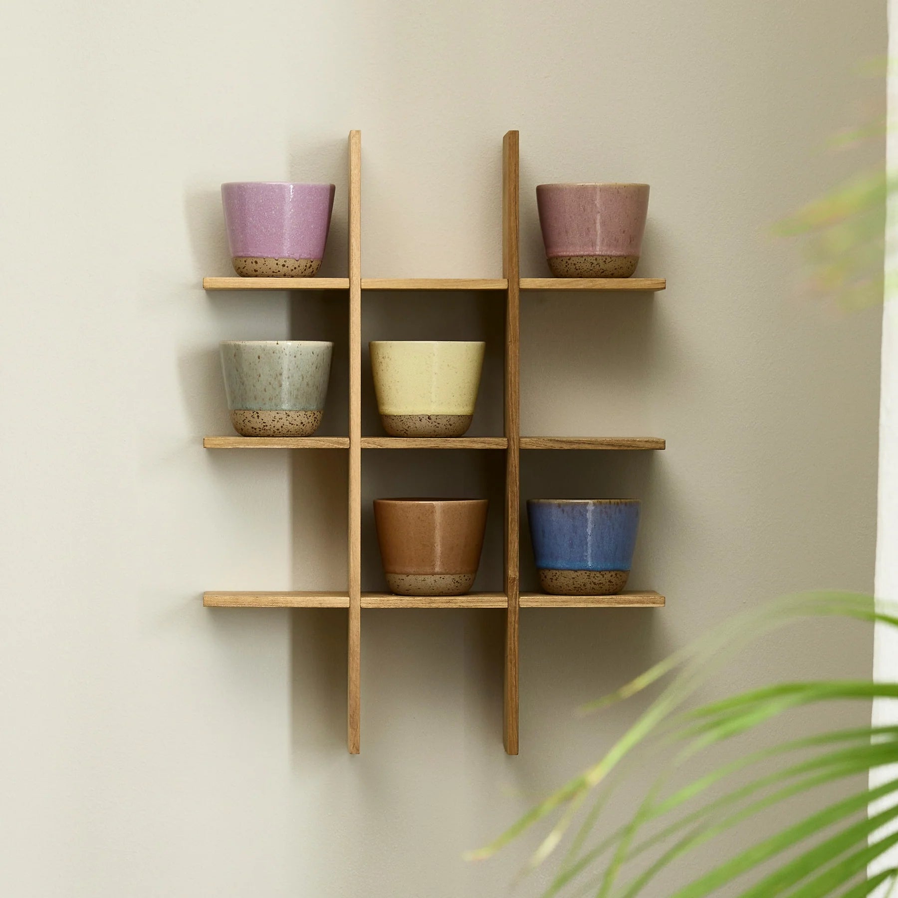 RAW Colour mugs by aida in mixed colours styled on a wall shelf