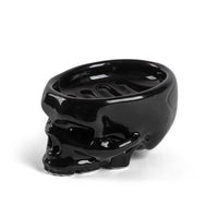 Side profile of glossy black skull soap tray showing drainage ridges
