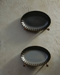 Green Inku oval serving bowls by Sergio Herman for Serax on a dark surface
