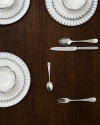 Serax Inku white plates laid on a dark dining table