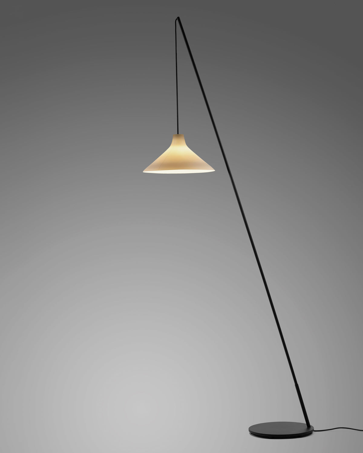 Serax Seam floor lamp switched on, glowing porcelain shade against a grey backdrop