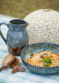 petrol green reactive glaze serving bowl filled with couscous outdoors
