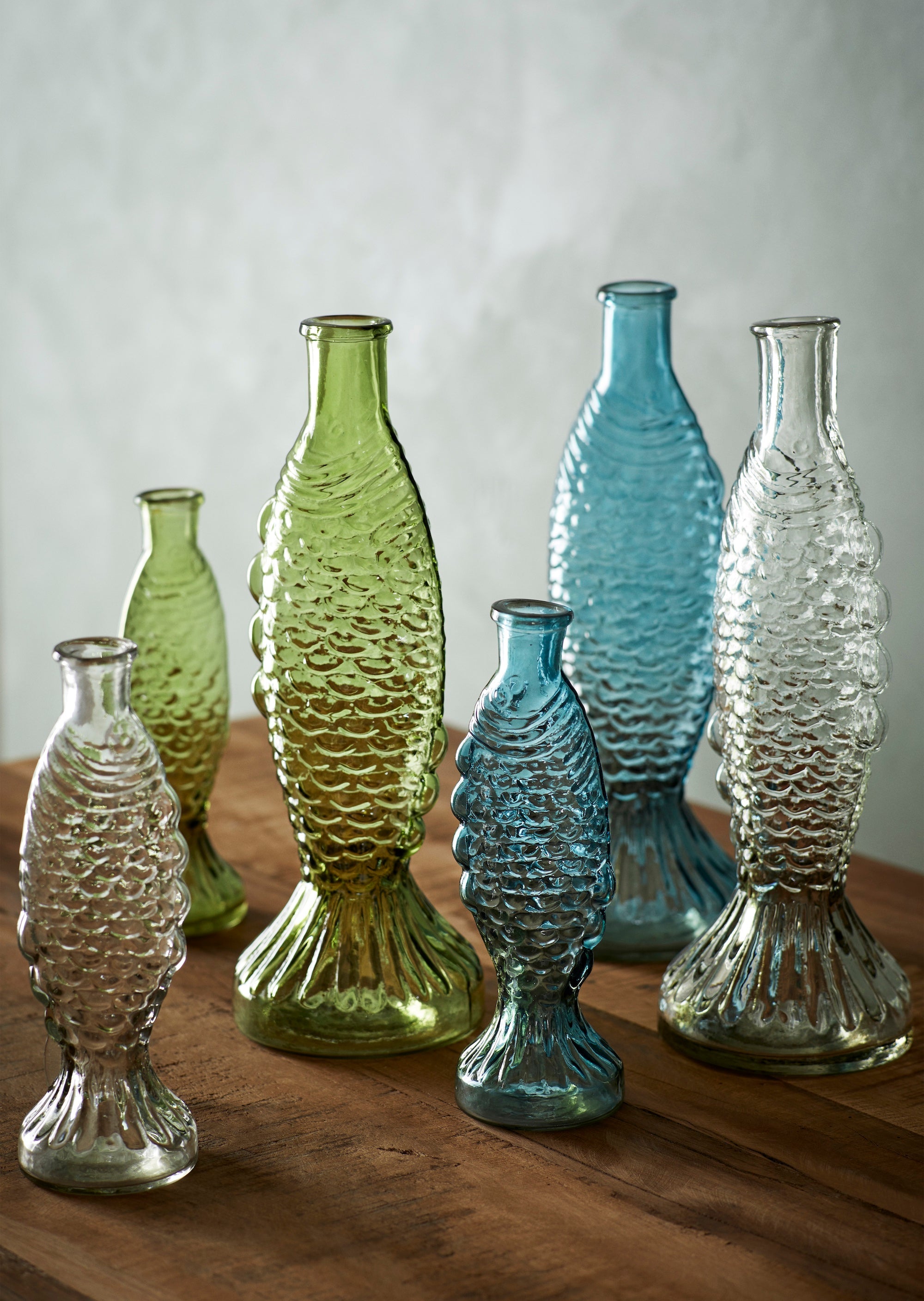 fish glass vases in clear, blue and green displayed together
