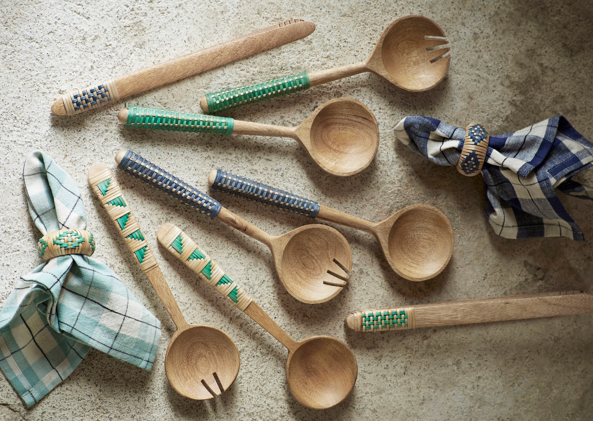 assortment of wooden kitchen tools with woven bamboo handles including green tongs
