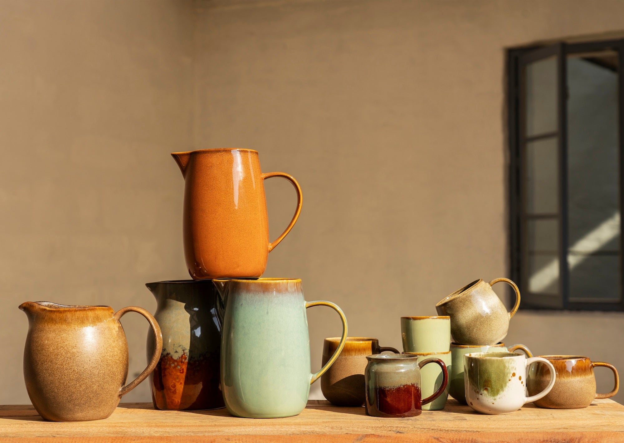 stoneware jug in petrol and brown with matching mugs and bowls
