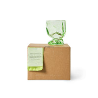 Single green peridot glass displayed on its packaging box
