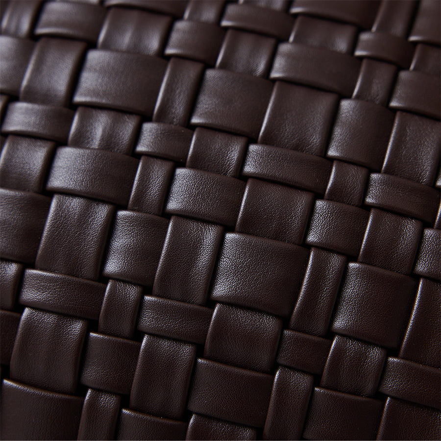 Close-up of woven basket-weave texture on chocolate brown faux leather cushion