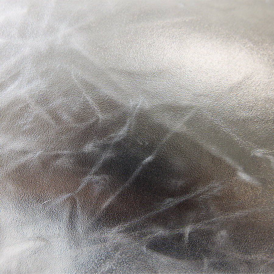 Close-up of crinkled metallic surface on silver faux leather cushion