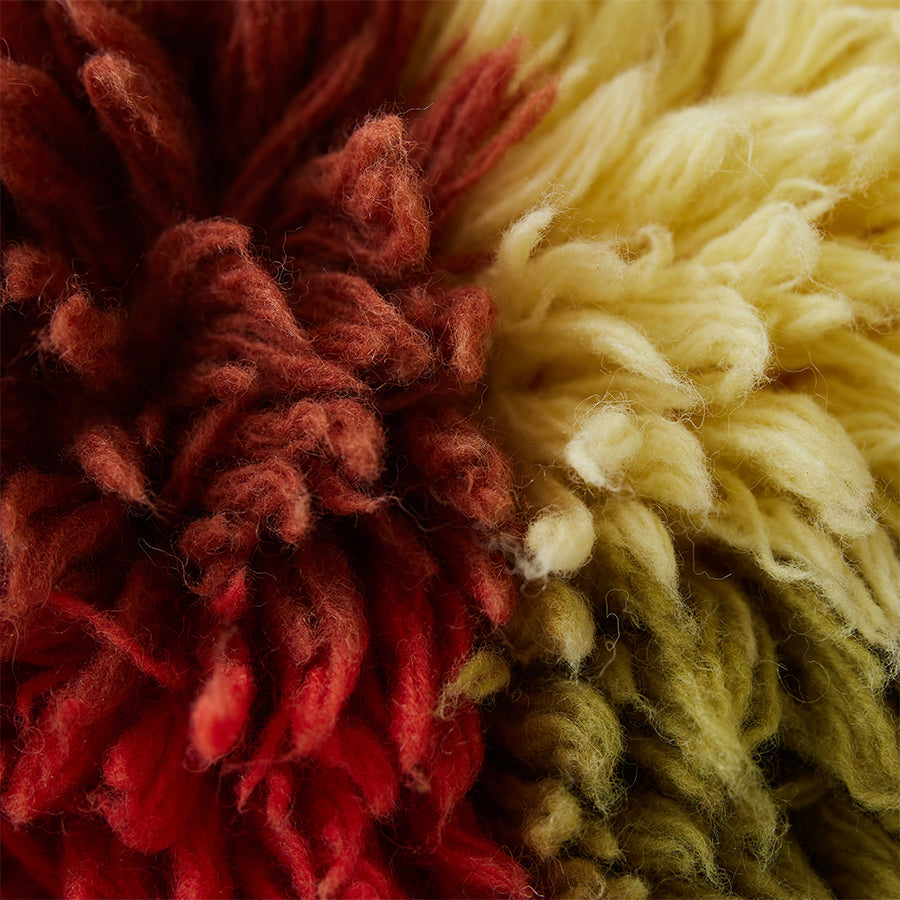 close-up of shaggy wool texture on HKLIVING multicolour cushion showing warm red orange yellow green tones
