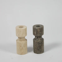 Light and dark asymmetric travertine candle holders by Olsson & Jensen side by side