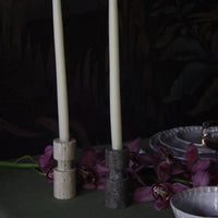 Travertine candle holders by Olsson & Jensen styled with purple flowers
