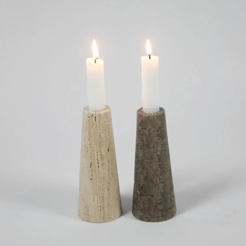 Light and dark travertine cone candle holders by Olsson & Jensen with lit candles