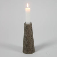 Dark travertine cone candle holder by Olsson & Jensen with a white candle