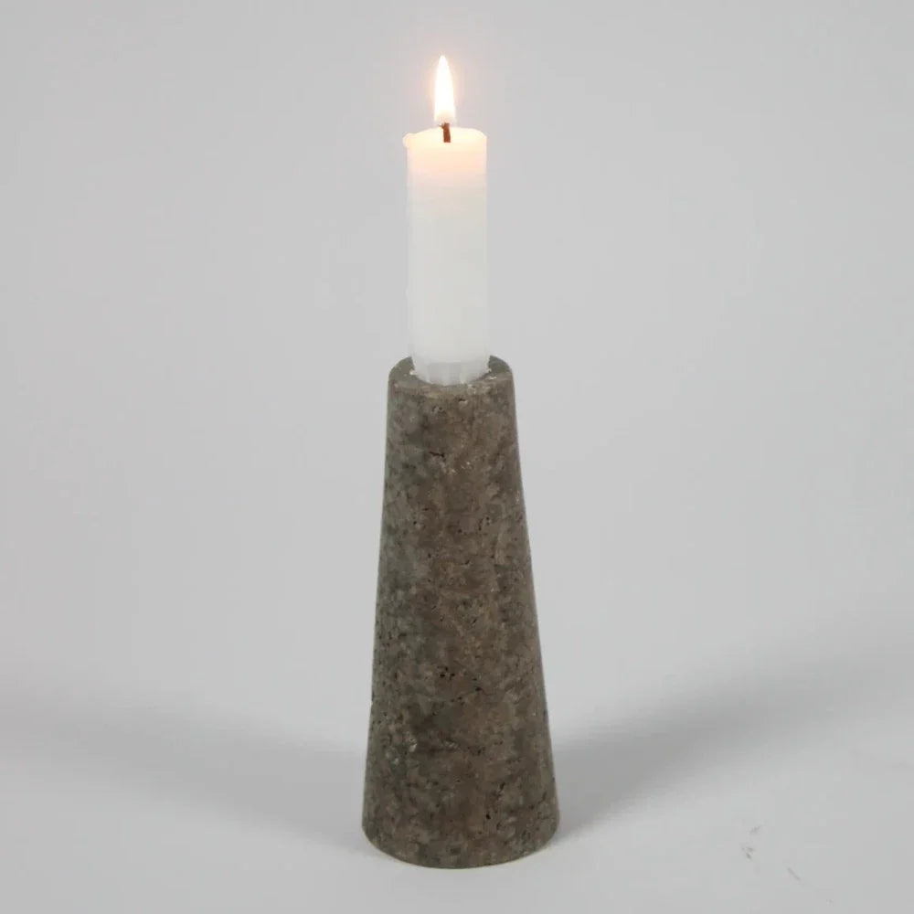 Dark travertine cone candle holder by Olsson & Jensen with a white candle