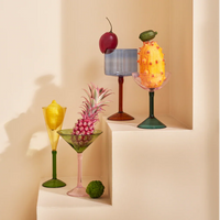 Urban Nature Culture cocktail glasses in mixed colours with fruit garnishes on stepped plinths