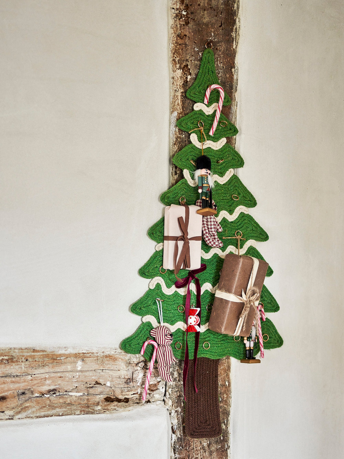 Felt Christmas tree wall hanging with small gifts and nutcracker ornaments
