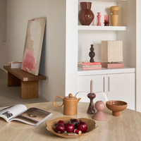 Urban Nature Culture ceramics on a white shelving unit beside a dining table